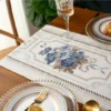 Table runner Camilla putih dengan motif bunga dalam penataan meja