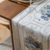 Table runner Camilla putih bermotif floral pada meja kayu