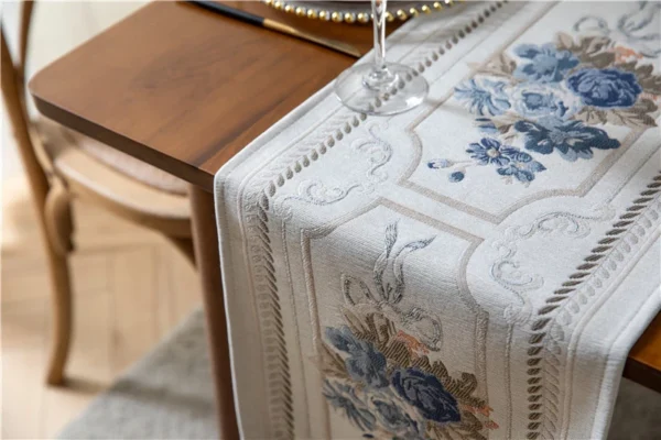 Table runner Camilla putih bermotif floral pada meja kayu