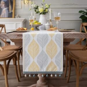 Table runner Vasa warna kuning dengan motif daun di meja makan